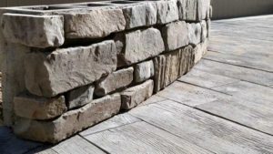 This blue and gray cobblestone veneer bench perfectly offsets the wood-stain patio pavers. Masonry by SR Custom Stone of Longmont, CO