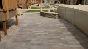The wood-stain pavers, offset by the rock veneer bench create a smooth transition between the wood porch and the neighbors wooden fence. Northern Colorado masonry by SR Custom Stone of Longmont.
