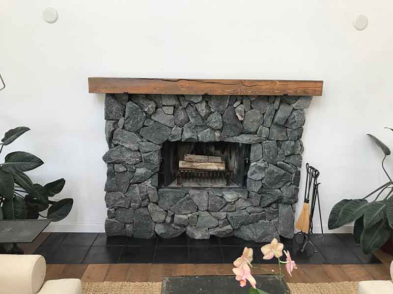This rip rap granite fireplace in Longmont, CO is nicely trimmed witha colorful beetle-kill mantle from our Colorado forests.