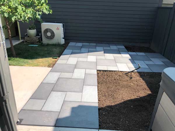 Porcelain all- and mixed-blue pavers create backyard patio and sidewalk in Prospect